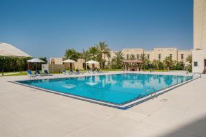 a large swimming pool at a resort at Acacia Hotel Ras Al Khaimah by AMR in Ras al Khaimah