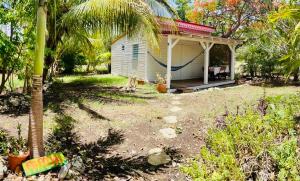 a small white house with a palm tree next to it at Kaz Menard in Saint-Louis