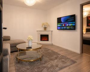 a living room with a coffee table and a fireplace at Azur House2 in Cluj-Napoca