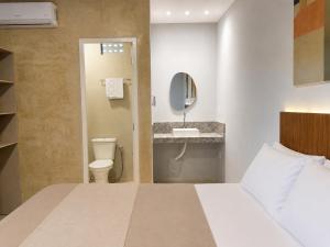 a bathroom with a bed and a sink and a toilet at Exclusive Hotel in Campos Sales +58 photos
