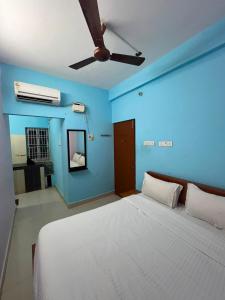 a blue room with a bed and a ceiling fan at The grand chateau in Singapperumālkovil +20 photos