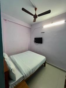 a bedroom with a bed with a ceiling fan at The grand chateau in Singapperumālkovil