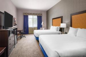 a hotel room with two beds and a flat screen tv at Best Western Plus Grant Creek Inn in Missoula