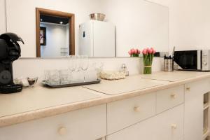 a kitchen counter with glasses and a microwave at Azur House2 in Cluj-Napoca
