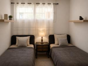 two beds in a room with a lamp and a window at Condado de Alhama - Suchan living in El Romero +19 photos