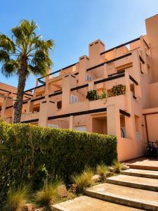 a building with a palm tree in front of it at Condado de Alhama - Suchan living in El Romero
