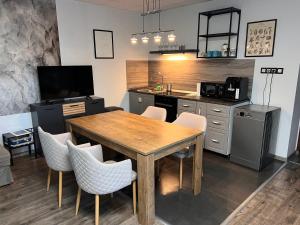 a kitchen with a wooden table and chairs at Filkes Rezidence in Filkeháza