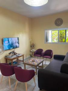 a living room with a couch and a table and chairs at Auberge Andel Diabou SARR in Palmarin
