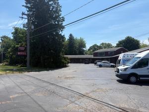 a parking lot with a white van parked in front of a motel at Keyes Motel in Arlington Heights +1 photo