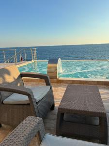 a swimming pool with two chairs and a table at Villa Bakic in Dobra Voda