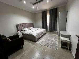 a bedroom with a bed and a couch and a table at شقة مخدومة 101 in Medina