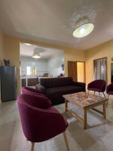 a living room with a couch and chairs and a table at Auberge Andel Diabou SARR in Palmarin