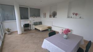 a living room with a table with a vase of flowers on it at Apartma pri Boru in Ptuj