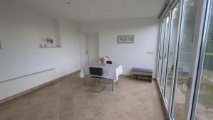 a white room with a table with a vase of flowers on it at Apartma pri Boru in Ptuj +5 photos
