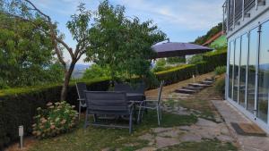 a table and chairs with an umbrella in a yard at Apartma pri Boru in Ptuj