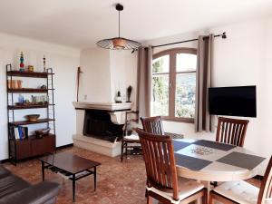 a living room with a table and a fireplace at Les messugues aux issambres in La Garonnette-Plage