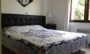 a bed with a quilt on it in a bedroom at Les messugues aux issambres in La Garonnette-Plage
