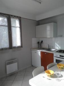 a kitchen with a table with chairs and a sink at Les messugues aux issambres in La Garonnette-Plage