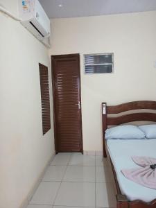 a bedroom with a bed and a closed door at Hotel Dunil in Araguaína