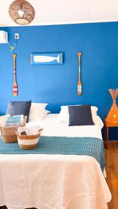 a blue bedroom with a bed with a blue wall at Recanto Manoah MAR in Caraíva