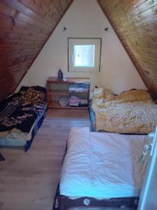 a attic bedroom with two beds and a window at Konak Vuk in Veruša