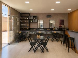 a bar with tables and chairs in a room at Exclusive Hotel in Campos Sales