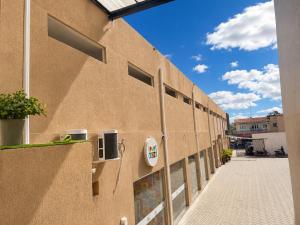 a brown building with a wall with a pay phone at Exclusive Hotel in Campos Sales