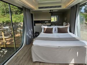 ein Schlafzimmer mit einem großen Bett und einem Balkon in der Unterkunft Forest Capsule in Uddevalla