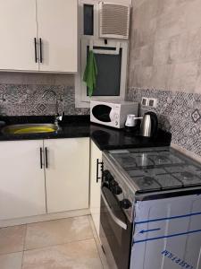 a kitchen with a sink and a stove top oven at New Alamein Latine district Spacious studio direct Lagon view in El Alamein