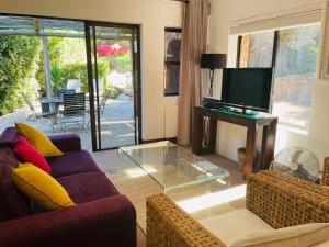 a living room with two couches and a tv at The Tarragon in Hout Bay