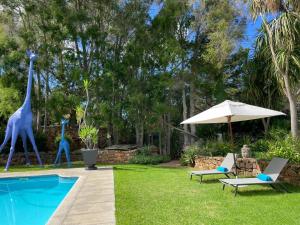 a yard with two giraffes statues next to a pool at The Tarragon in Hout Bay