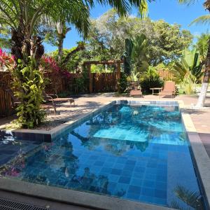 a pool with blue tiles in a backyard with palm trees at Pousada Sky Dream Beach Mutá Frente Mar By LVF in Porto Seguro +78 photos