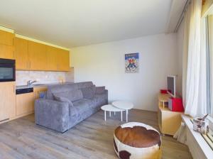 a living room with a couch and a table at Magnifique appartement avec vue sur les sommets enneigés in Crans-Montana