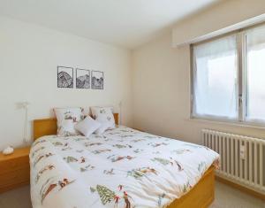 a bedroom with a bed and a window at Magnifique appartement avec vue sur les sommets enneigés in Crans-Montana