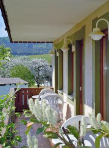 a row of white chairs sitting on a building at Hotel Lugerhof in Weiding