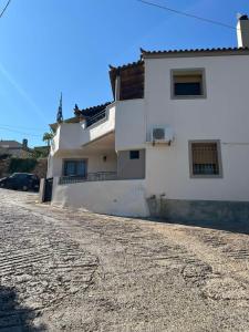 a white house on a cobblestone street at Matina's cozy home close to Monemvasia in Áyios Sarándos