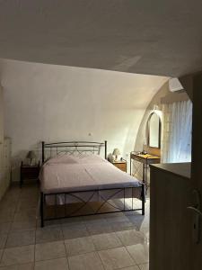 a bedroom with a bed and a table with a mirror at Matina's cozy home close to Monemvasia in Áyios Sarándos