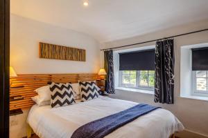 a bedroom with a large bed and two windows at 3 Bed in Eype oc-e34183 in West Bay