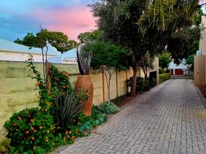 a brick walk way with flowers and a fence at Cosy Stay in Robertson