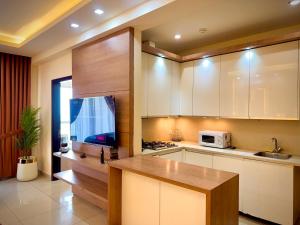 Eine Küche mit weißen Schränken, Spüle und Mikrowelle in der Unterkunft Executive Penta Studio Luxury Apartments DHA Lahore in Lahore