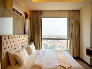 ein Schlafzimmer mit einem Bett und einem großen Fenster in der Unterkunft Executive Penta Studio Luxury Apartments DHA Lahore in Lahore