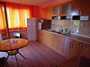 a kitchen with a table and a sink and a refrigerator at Guest House Olimpiya in Sveti Vlas
