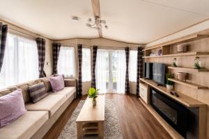 a living room with a couch and a tv at Forest & Beach Escape in Sway