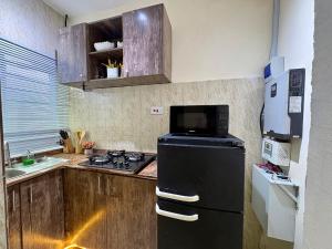 a kitchen with a black refrigerator and a stove at Haven 21 in Aja