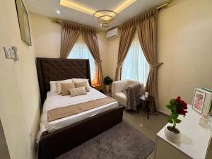 a bedroom with a large bed and a chair at Haven 21 in Aja