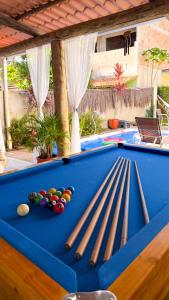 a pool table with cue balls and bats on it at Recanto Manoah MAR in Caraíva