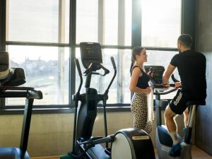 a man and a woman on exercise bikes in a gym at Euler Neuschönau - 4 Sterne Superior Hotel in Neuschönau