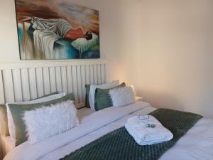 a bedroom with two beds with pillows and a painting at Cosy Stay in Robertson