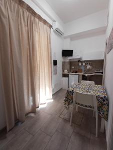 a table and chairs in a room with a kitchen at Studio 23 in Partinico