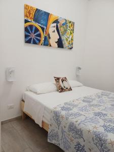 a bedroom with a bed and a painting on the wall at Studio 23 in Partinico